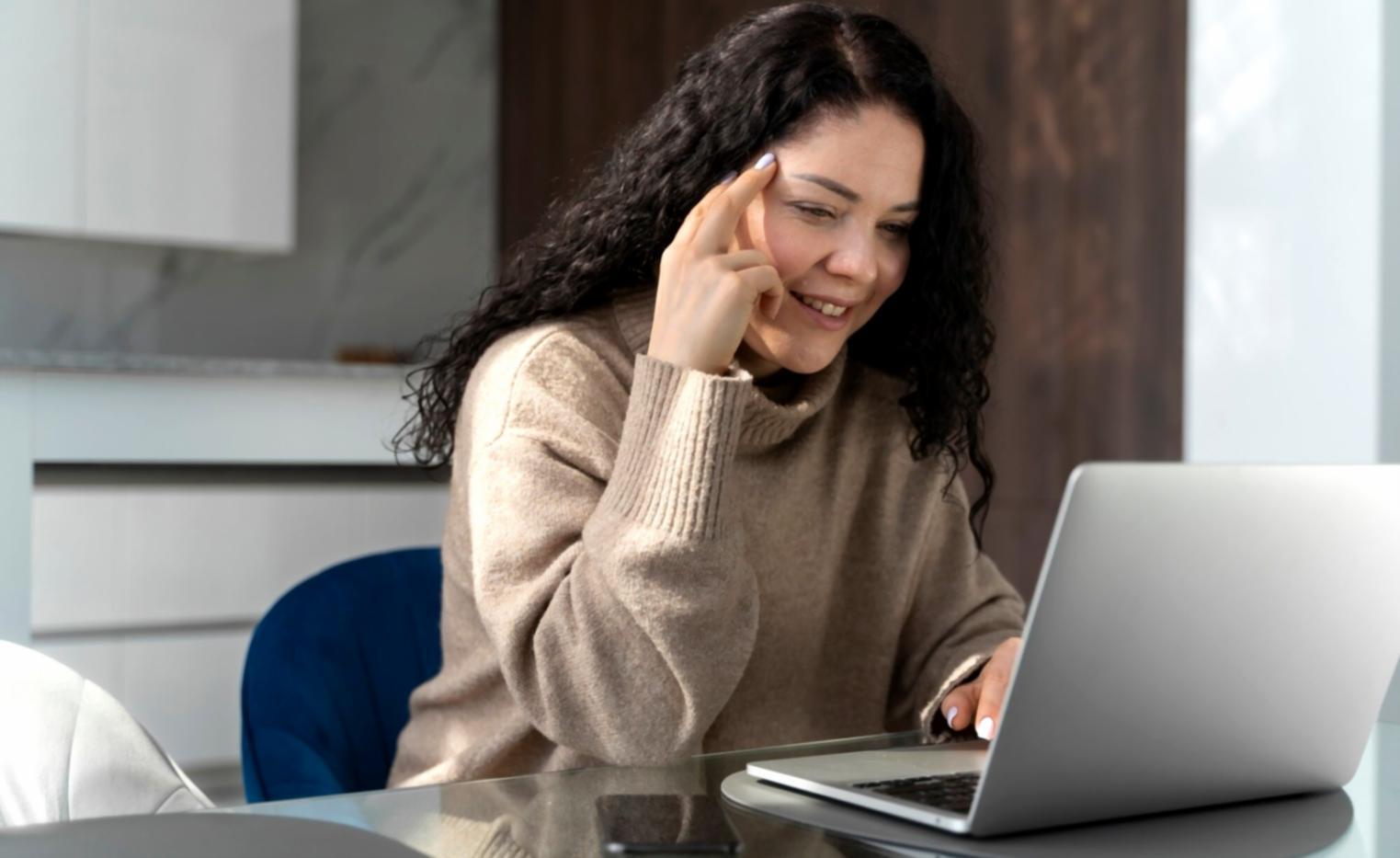 Study materials and resources displayed on a desk with laptop showing financial analysis software